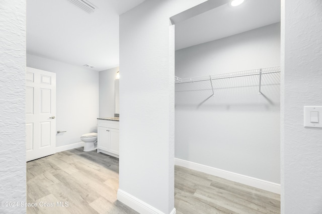 bathroom with hardwood / wood-style flooring, vanity, and toilet