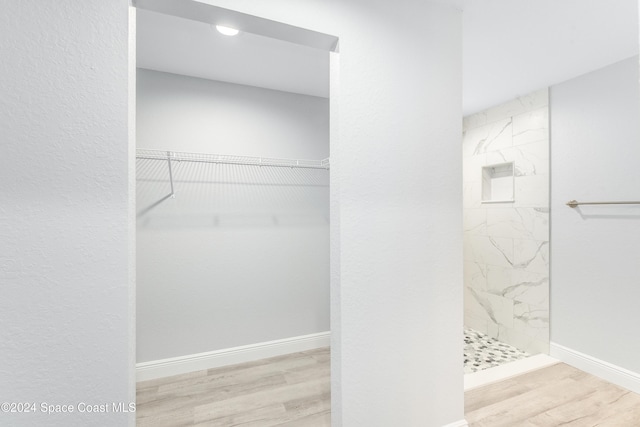 bathroom featuring tiled shower and hardwood / wood-style floors