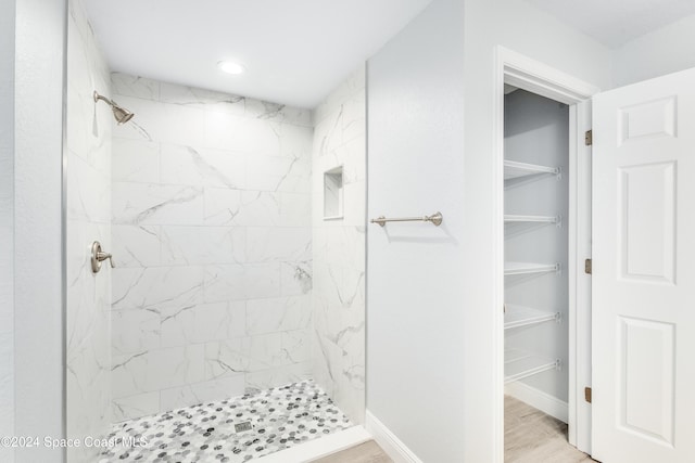 bathroom featuring hardwood / wood-style flooring and a tile shower