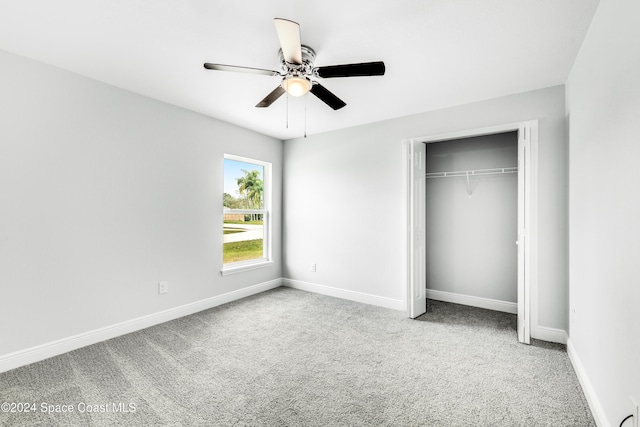 unfurnished bedroom with ceiling fan, light carpet, and a closet