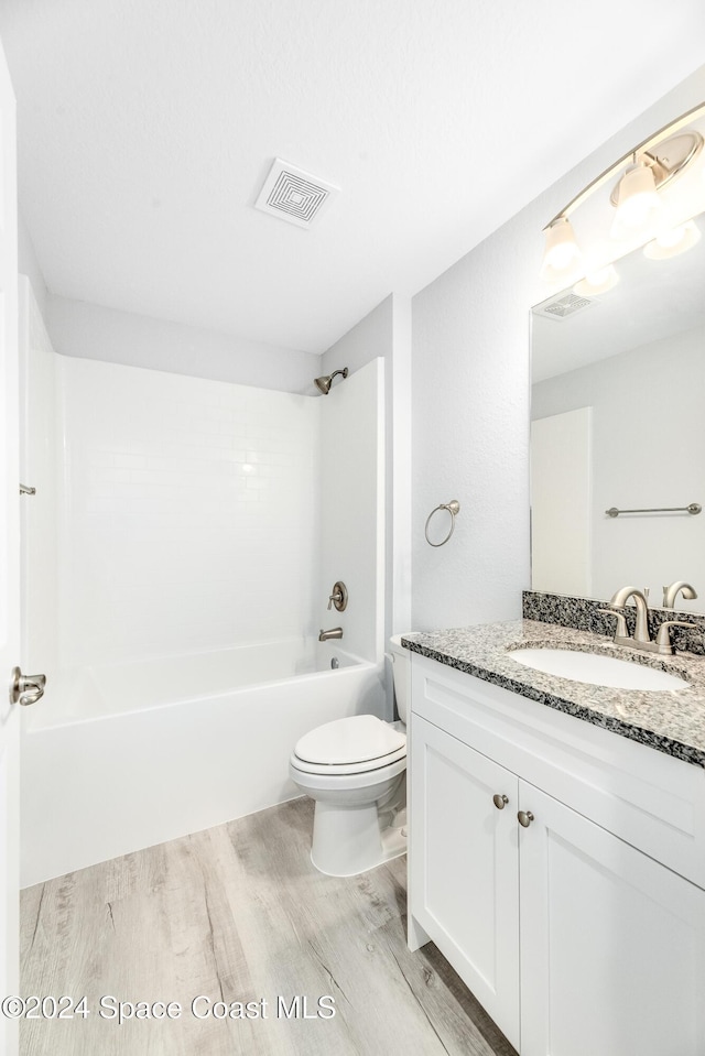 full bathroom featuring toilet, vanity, bathtub / shower combination, and hardwood / wood-style flooring