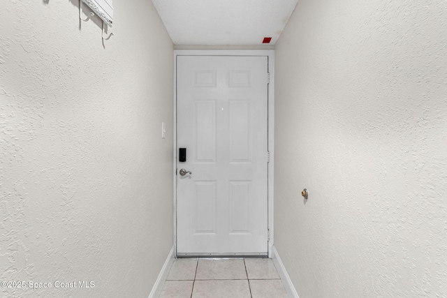 entryway with light tile patterned floors and a textured ceiling