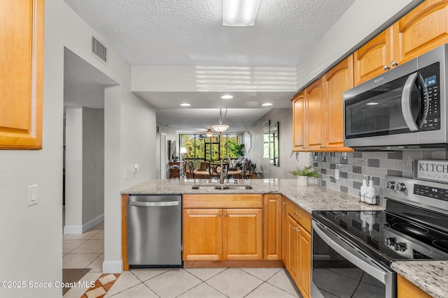 kitchen featuring sink, light tile patterned floors, appliances with stainless steel finishes, tasteful backsplash, and light stone counters