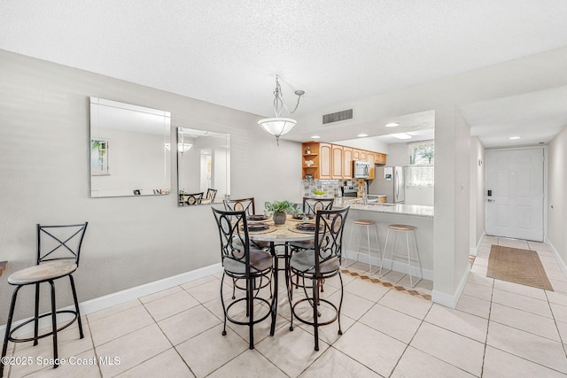 dining room with light tile patterned floors and a textured ceiling