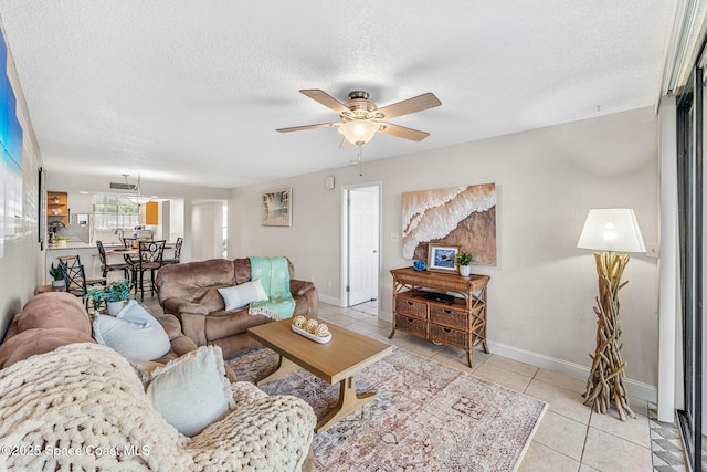 living room featuring ceiling fan, light tile patterned flooring, and a textured ceiling