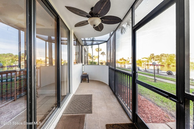 unfurnished sunroom featuring ceiling fan