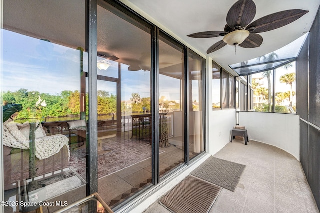 unfurnished sunroom featuring ceiling fan