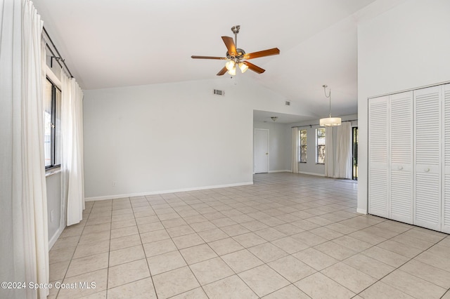 spare room with ceiling fan, light tile patterned flooring, and vaulted ceiling