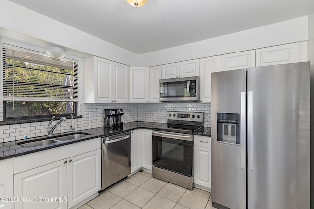 kitchen with white cabinets, light tile patterned floors, stainless steel appliances, and sink