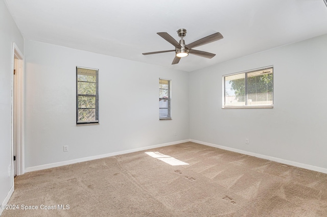 carpeted spare room featuring ceiling fan