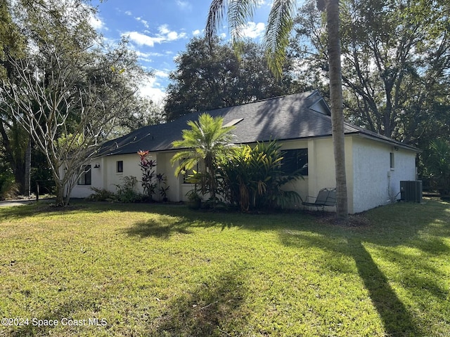 view of property exterior with central AC unit and a lawn