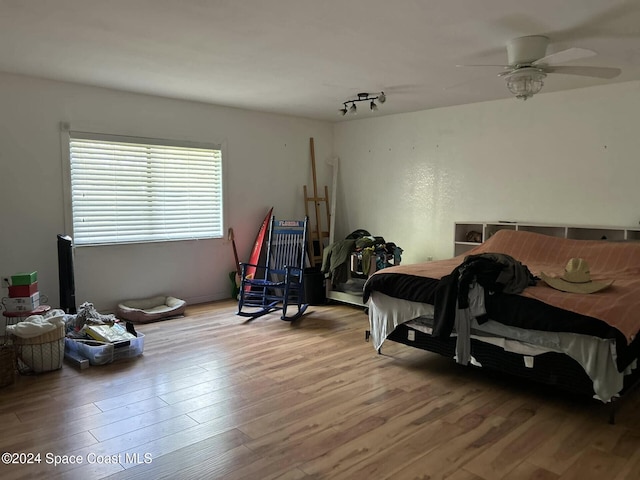 bedroom featuring light wood-type flooring, rail lighting, and ceiling fan