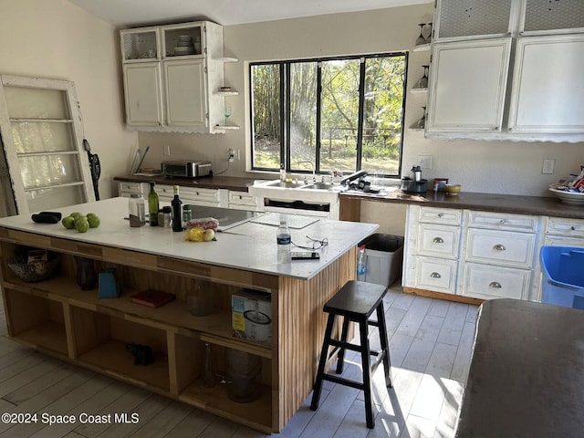 kitchen featuring white cabinets, light wood-type flooring, and a center island