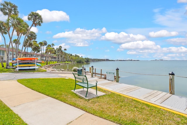 dock area with a lawn and a water view