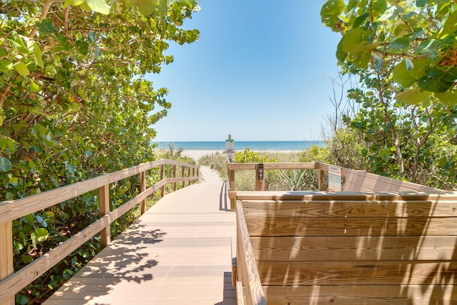 surrounding community with a water view and a view of the beach