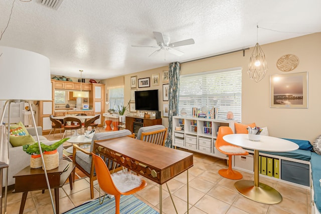 dining area featuring a textured ceiling, ceiling fan, and light tile patterned flooring