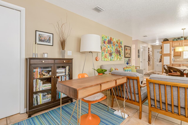 dining area with sink, a textured ceiling, and light tile patterned flooring