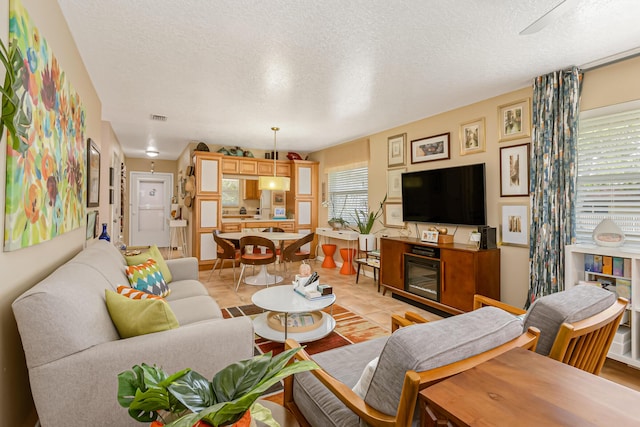 living room featuring light tile patterned floors and a textured ceiling