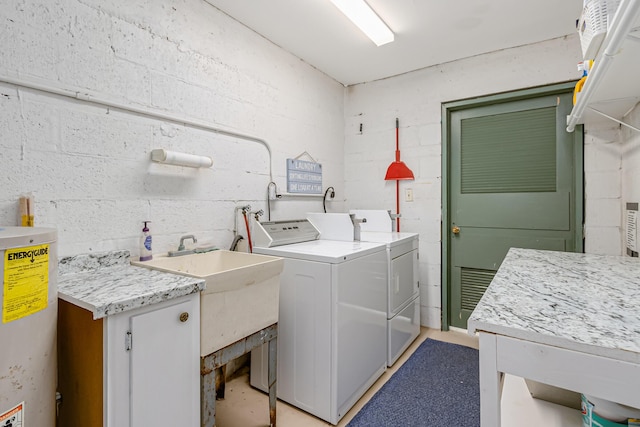 washroom featuring sink, washing machine and dryer, and water heater