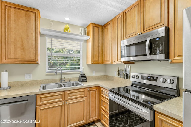 kitchen featuring appliances with stainless steel finishes, a textured ceiling, and sink