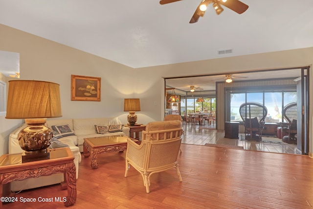 living room with light hardwood / wood-style flooring and vaulted ceiling