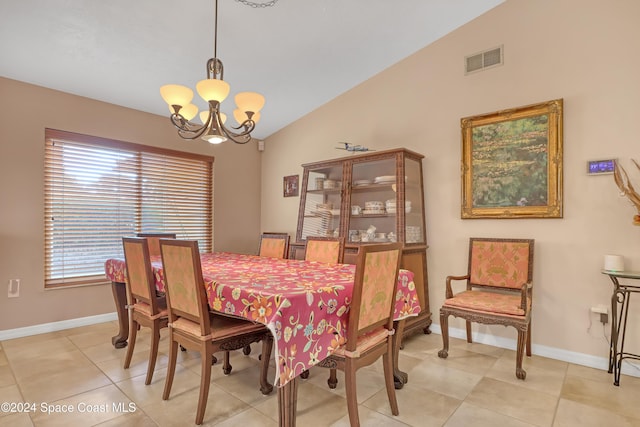 tiled dining space with a chandelier and vaulted ceiling