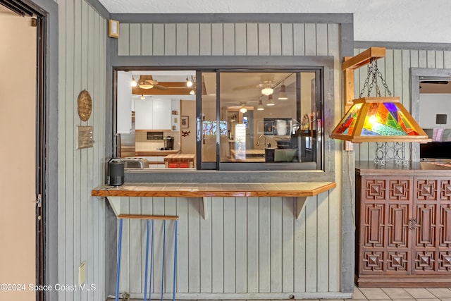 bar featuring wooden walls and light tile patterned flooring