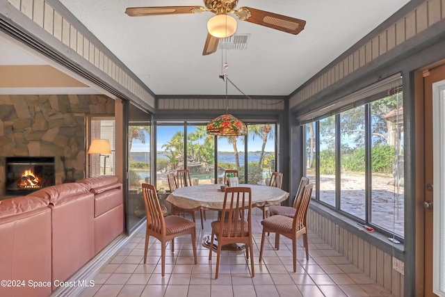 sunroom / solarium with ceiling fan and a fireplace