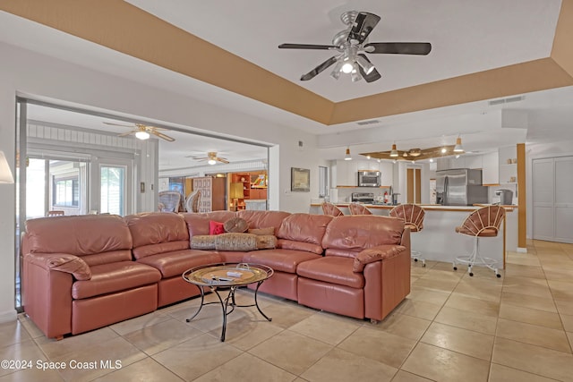 tiled living room featuring a tray ceiling