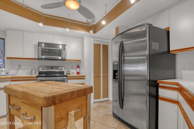 kitchen with white cabinets, a center island, appliances with stainless steel finishes, and tasteful backsplash