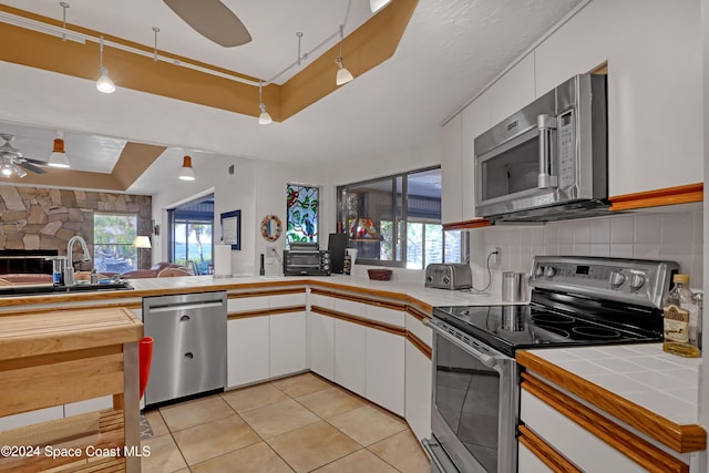 kitchen featuring tile countertops, sink, white cabinets, and appliances with stainless steel finishes