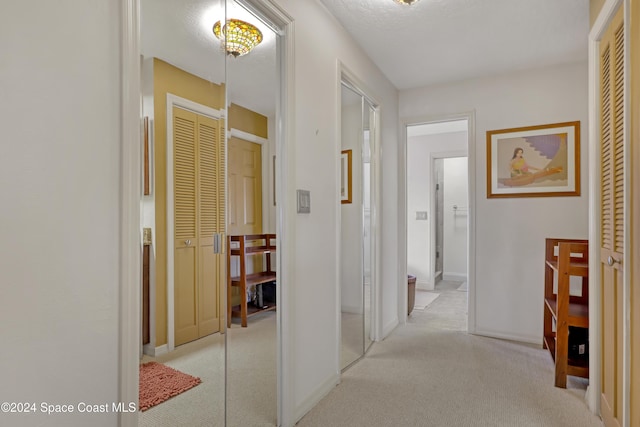 corridor featuring light colored carpet