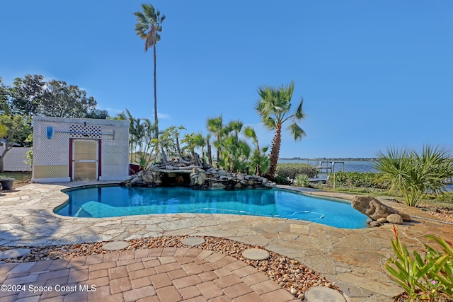 view of swimming pool featuring a water view and a patio