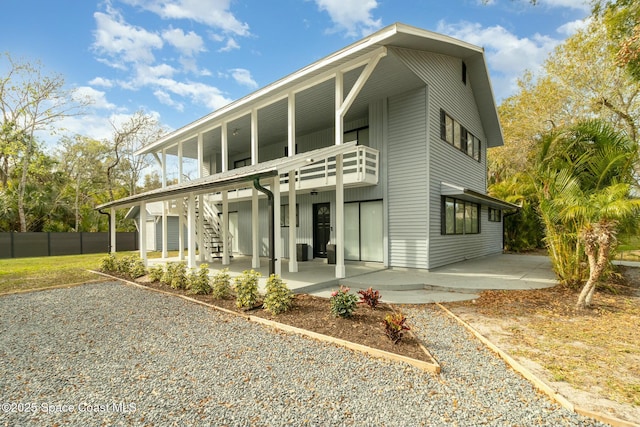 back of property with a balcony and a patio