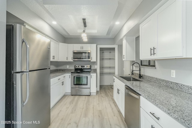 kitchen featuring sink, white cabinetry, a textured ceiling, and appliances with stainless steel finishes