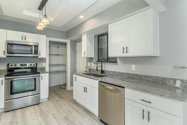 kitchen with white cabinetry, sink, a textured ceiling, and appliances with stainless steel finishes