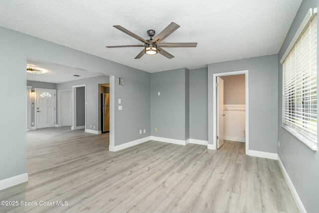 interior space featuring ceiling fan, light hardwood / wood-style floors, and a textured ceiling