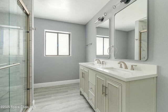 bathroom featuring vanity, wood-type flooring, and a shower with shower door