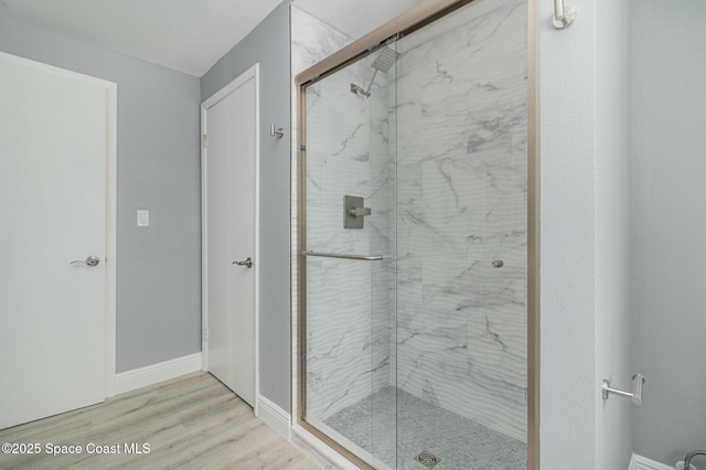 bathroom with wood-type flooring and a shower with shower door