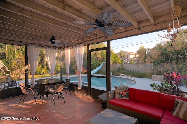 sunroom featuring ceiling fan, wood ceiling, and beamed ceiling