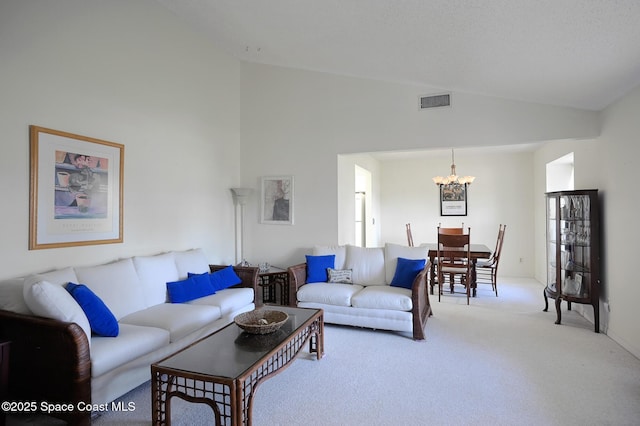 living room featuring carpet, vaulted ceiling, and a notable chandelier