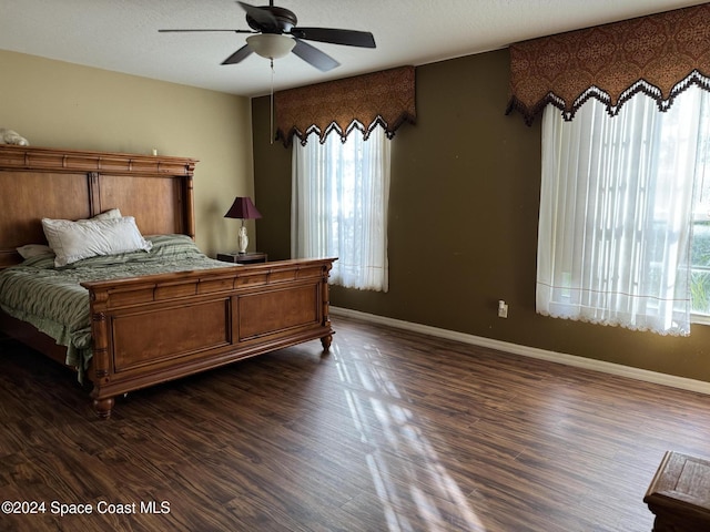 bedroom featuring ceiling fan, dark hardwood / wood-style flooring, a textured ceiling, and multiple windows