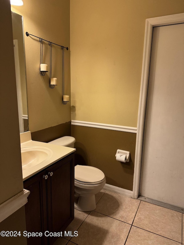 bathroom with tile patterned flooring, vanity, and toilet