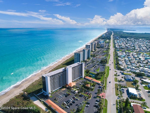 bird's eye view featuring a water view and a beach view