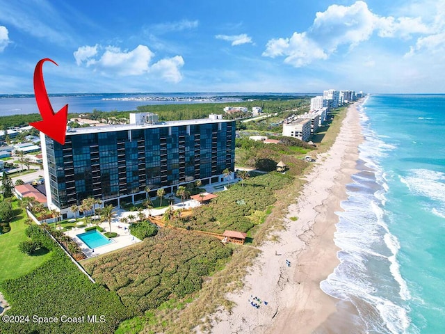 birds eye view of property featuring a beach view and a water view