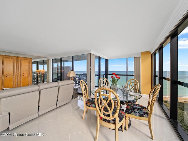 dining space featuring light tile patterned floors, a water view, and floor to ceiling windows