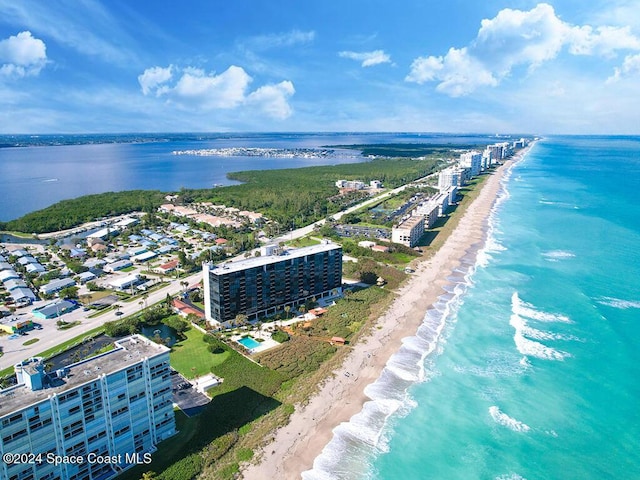 drone / aerial view featuring a water view and a beach view