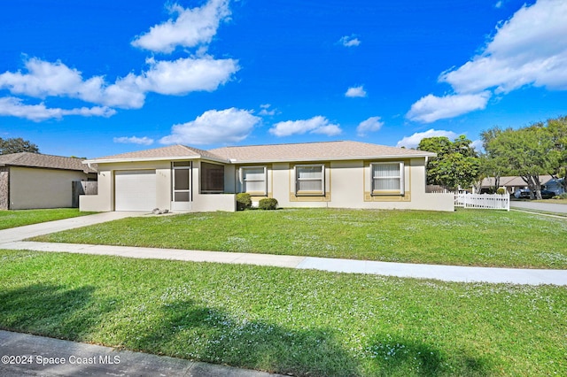 single story home featuring a garage and a front yard