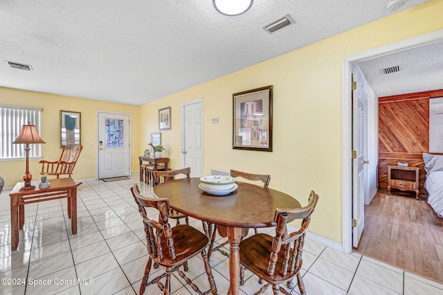 tiled dining space with a textured ceiling