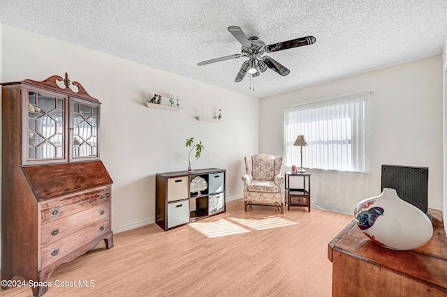 sitting room featuring a textured ceiling, hardwood / wood-style flooring, and ceiling fan